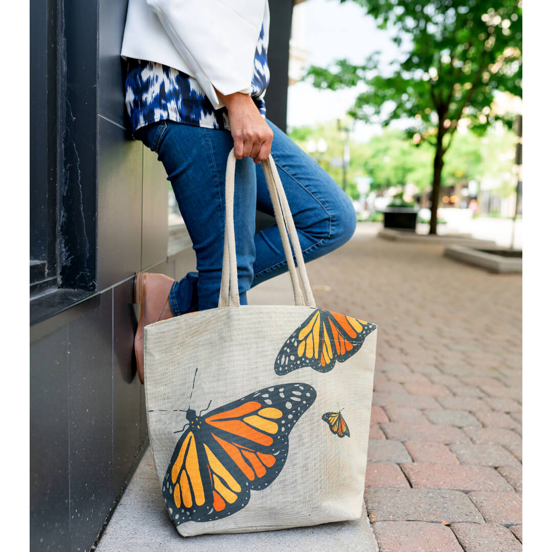 lady on street holding burlap tote with butterfly print